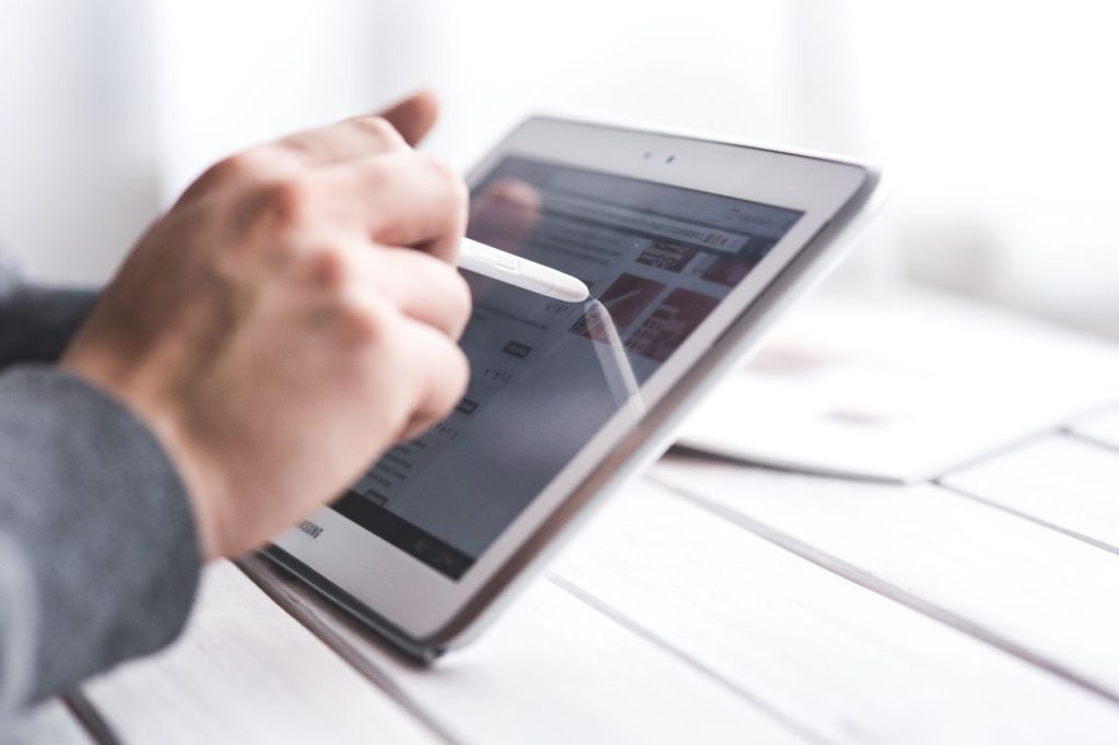 Crafting Captivating Headlines: Your awesome post title goes here Close-up of a hand using a stylus on a tablet, showcasing digital technology interaction.